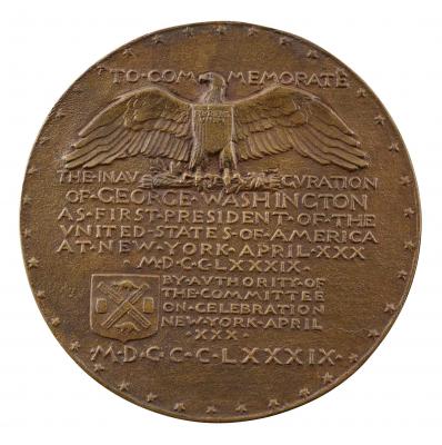 Bronze medal of a bald eagle, displayed with the American arms