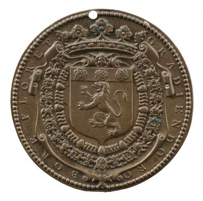 Bronze medal of crowned coat of arms with lion and 3 roses on top, bordered by embellishments.