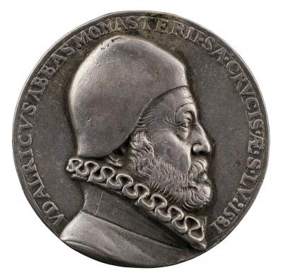 Silver medal of a man with a beard, wearing a skullcap and a coat with a ruff