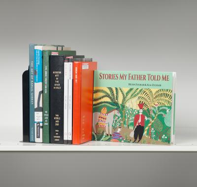 Book stack with one cover turned out with a colorful artwork of figures and a horse in a landscape