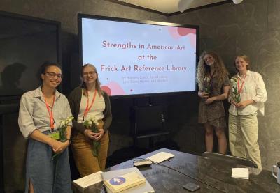 Four interns around a screen reading "Strengths in American Art at the Frick Art Reference Library"