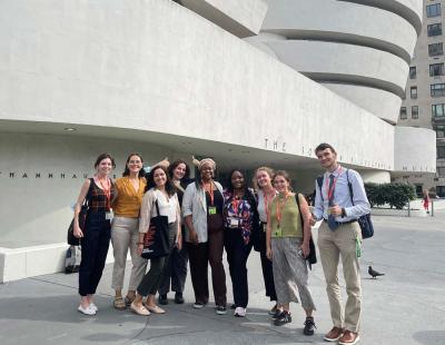 Nine people posing in front of the white Guggenheim Museum building