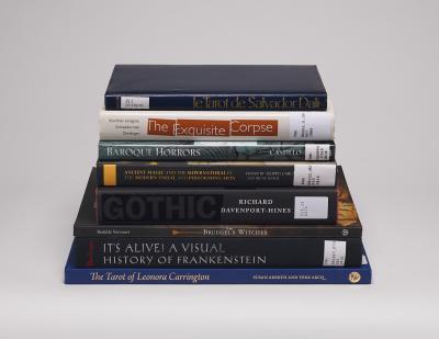 Horizontal stack of eight Halloween-themed books with spines showing