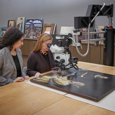Two conservators seated at a table in a lab