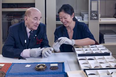 photo of Stephen K. Scher, along with Aimee Ng, handling medals