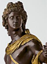 closeup of bronze statuette of Greek god, Apollo wearing gilded cape