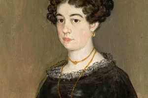 portrait of young woman in black dress wearing gold necklace