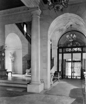 interior with staircase to left and archway over doors to outside