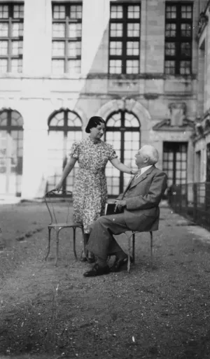 Mme. Clotilde Brière with seated man outside , circa 1945