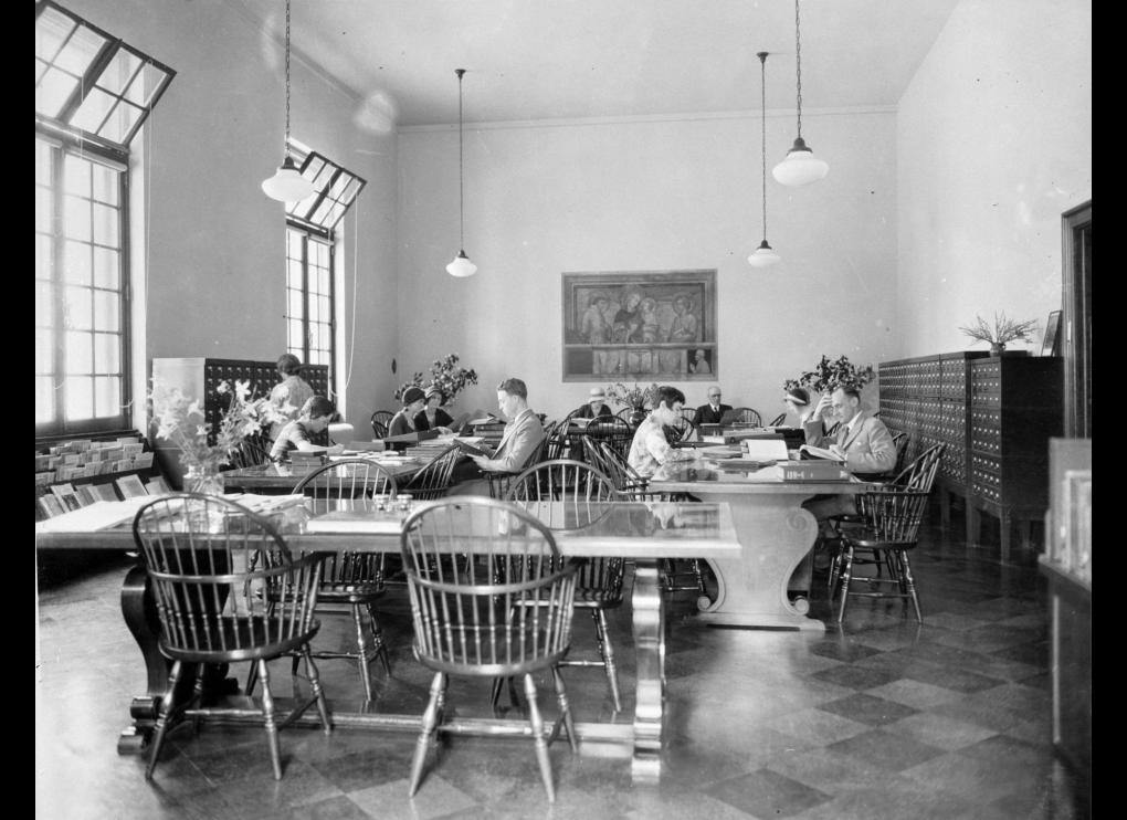 men and women seated at large tables in library, circa 1931-1934