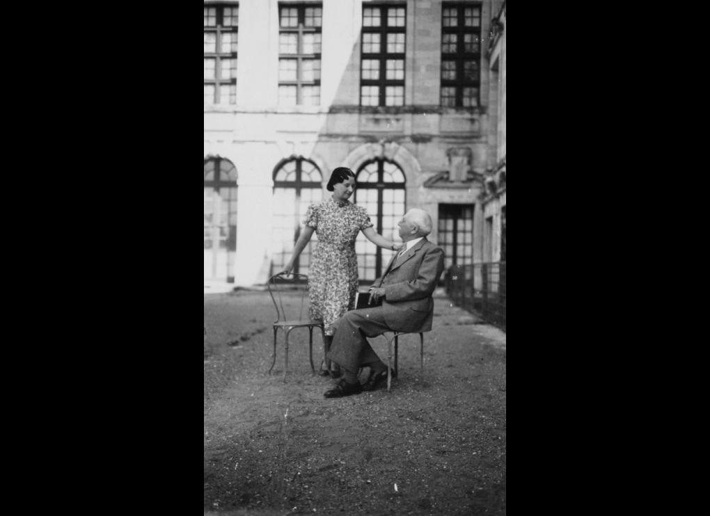 Mme. Clotilde Brière with seated man outside , circa 1945